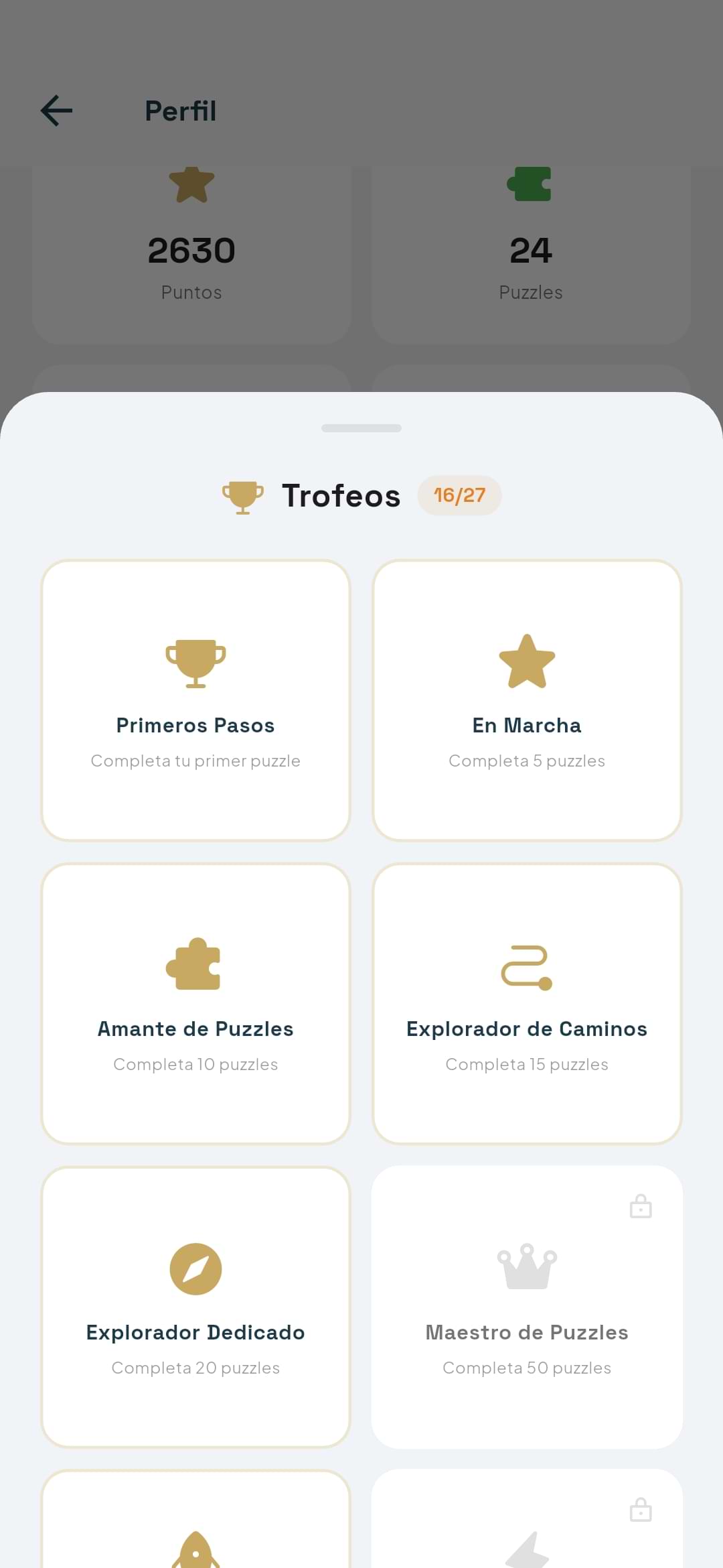 Trophies collection showing 16 of 27 unlocked, including Primeros Pasos, En Marcha, Amante de Puzzles, and locked achievements like Maestro de Puzzles